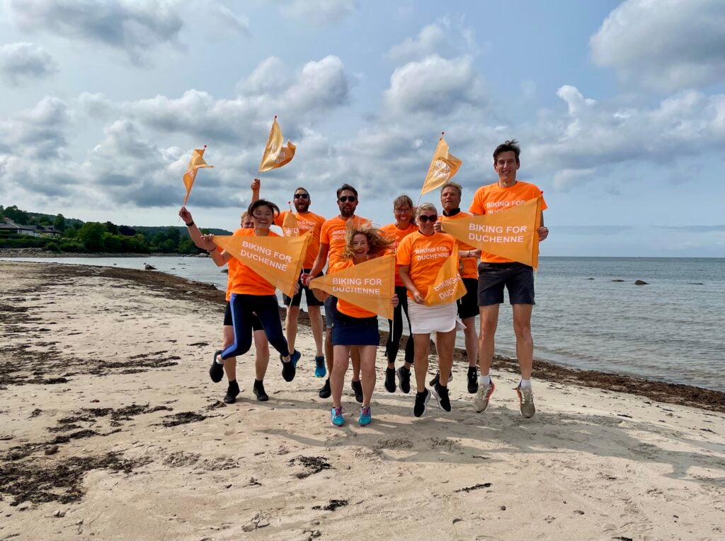 PTC employees jumping on the beach in celebration of De Duchenne 40